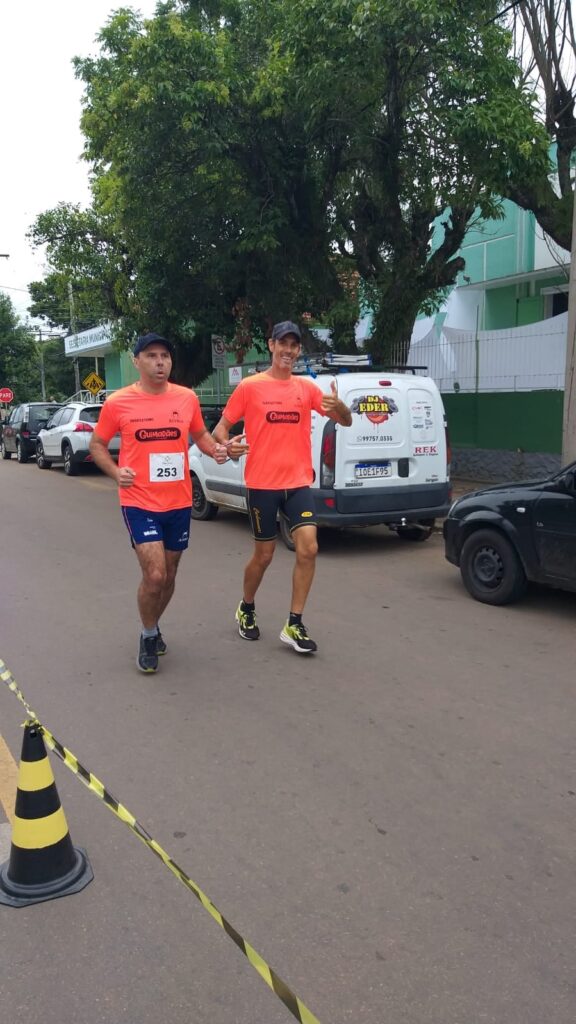 Início da descrição:
Glailton e guia José Márcio correndo, ambos vestem camiseta laranja da ACERGS.
Fim da descrição.
