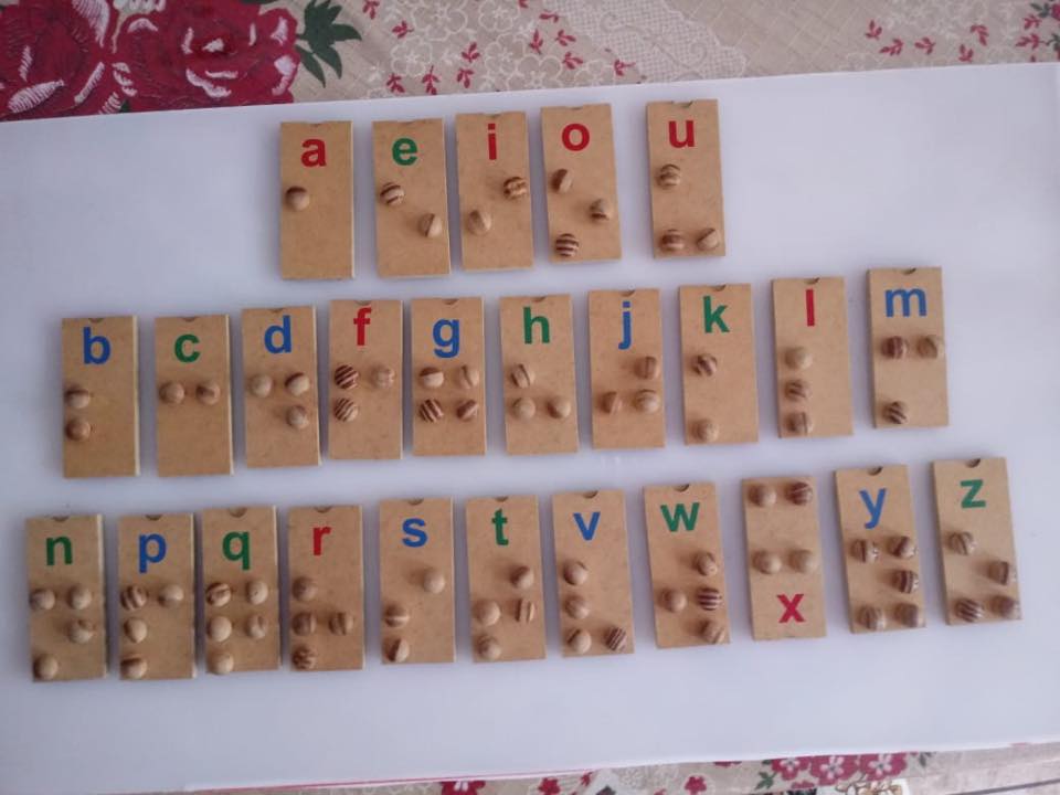 Descrição da imagem: Alfabeto Braille em peças de madeira. Fim da descrição.